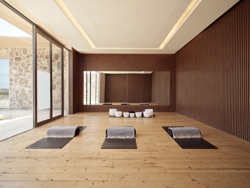 Yoga and meditation studio with mats, blankets, and singing bowls arranged for a wellness session